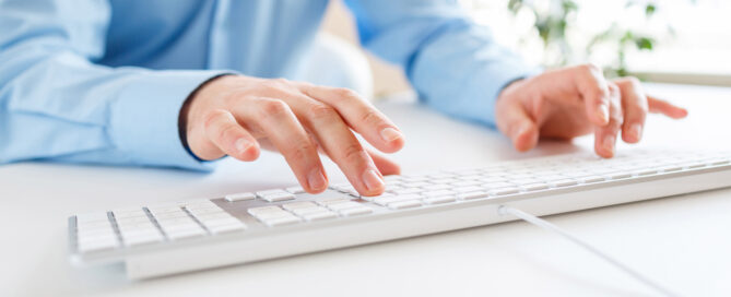 man typing on apple keyboard