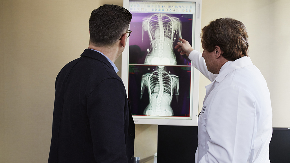 doctor and patient looking at spine x-rays