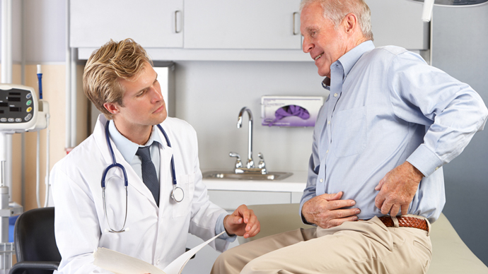 doctor examines older man with hip pain