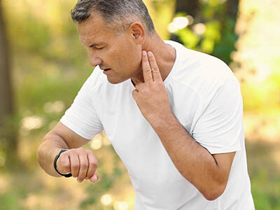 Man checking pulse outdoors on sunny day