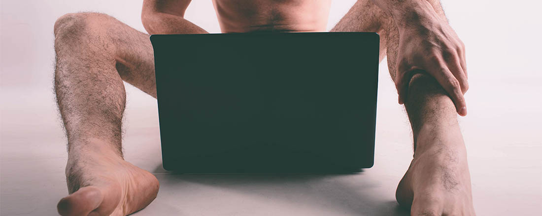 Young naked man watching pornography and masturbating.