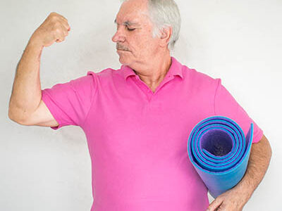 healthy white fit smiling happy senior man stand and hold mat in