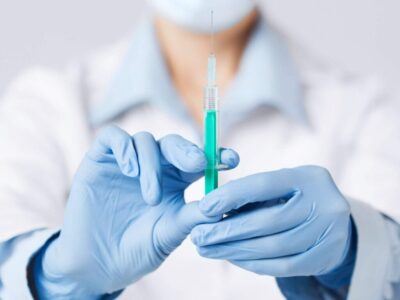 Denver Stem Cell Therapy: Person in white coat and blue gloves holds syringe for medical procedure