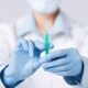 Denver Stem Cell Therapy: Person in white coat and blue gloves holds syringe for medical procedure