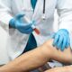 Doctor administering an injection to patient's knee for medical treatment | Denver stem cell therapy