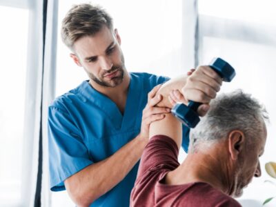 Doctor helping old man doing arm exercise | Denver Stem Cell Therapy